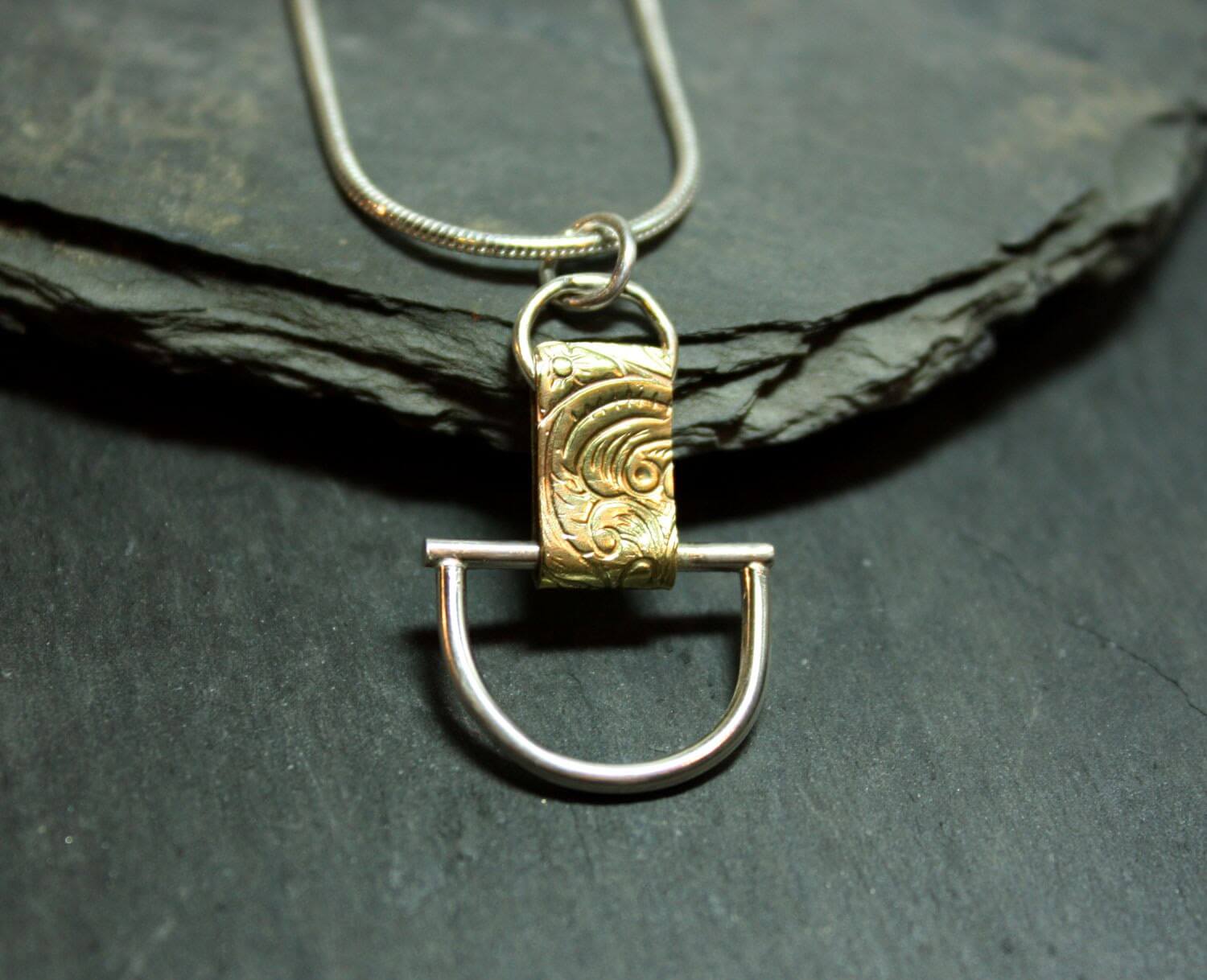 Arkitekturinspirerat handgjort silverhalsband av silver och mässing