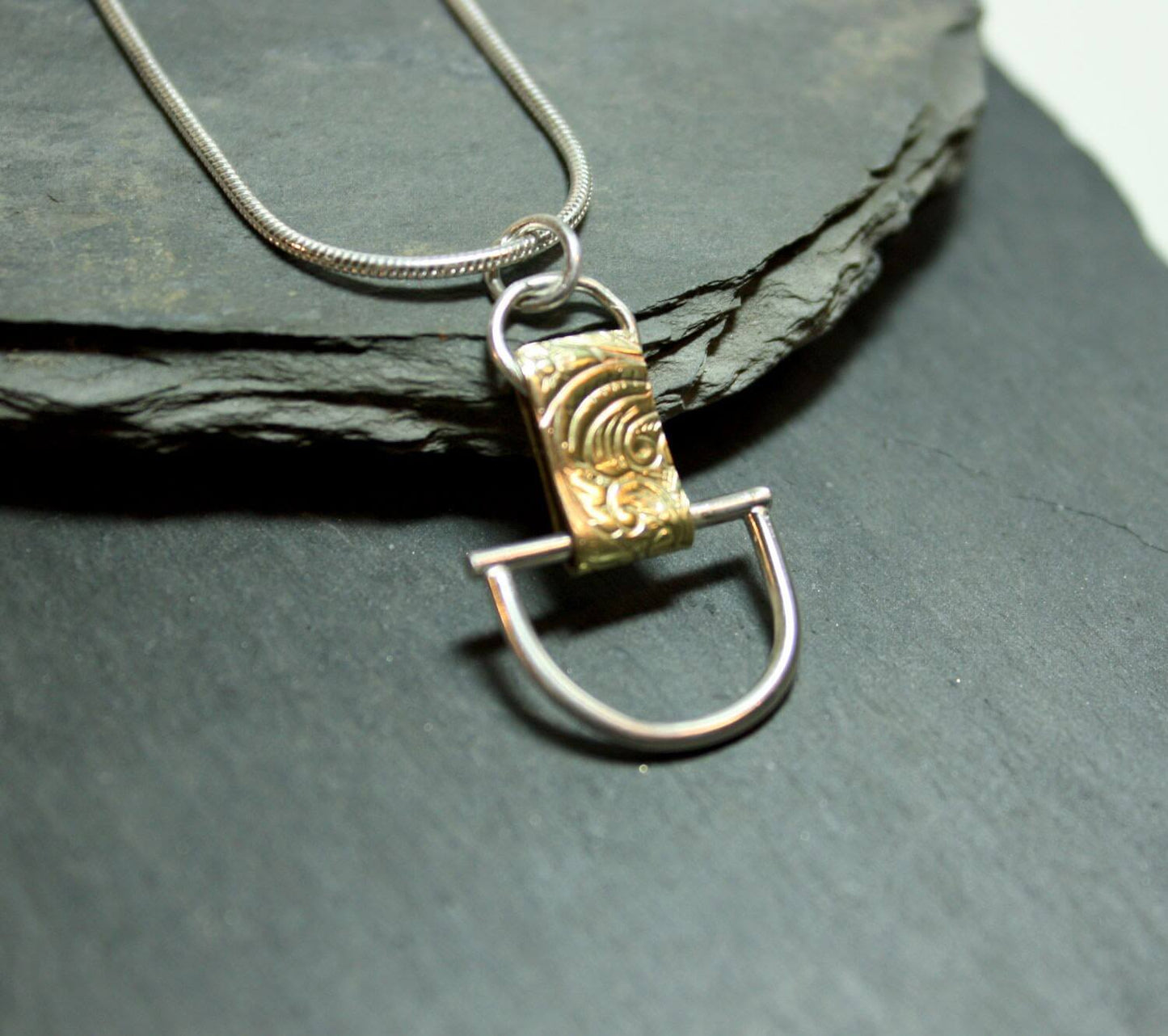 Arkitekturinspirerat handgjort silverhalsband av silver och mässing