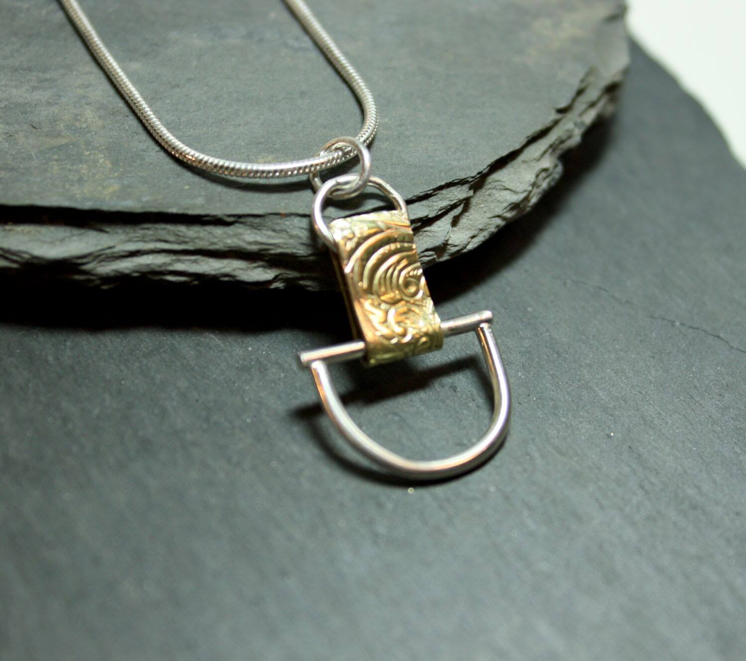Arkitekturinspirerat handgjort silverhalsband av silver och mässing