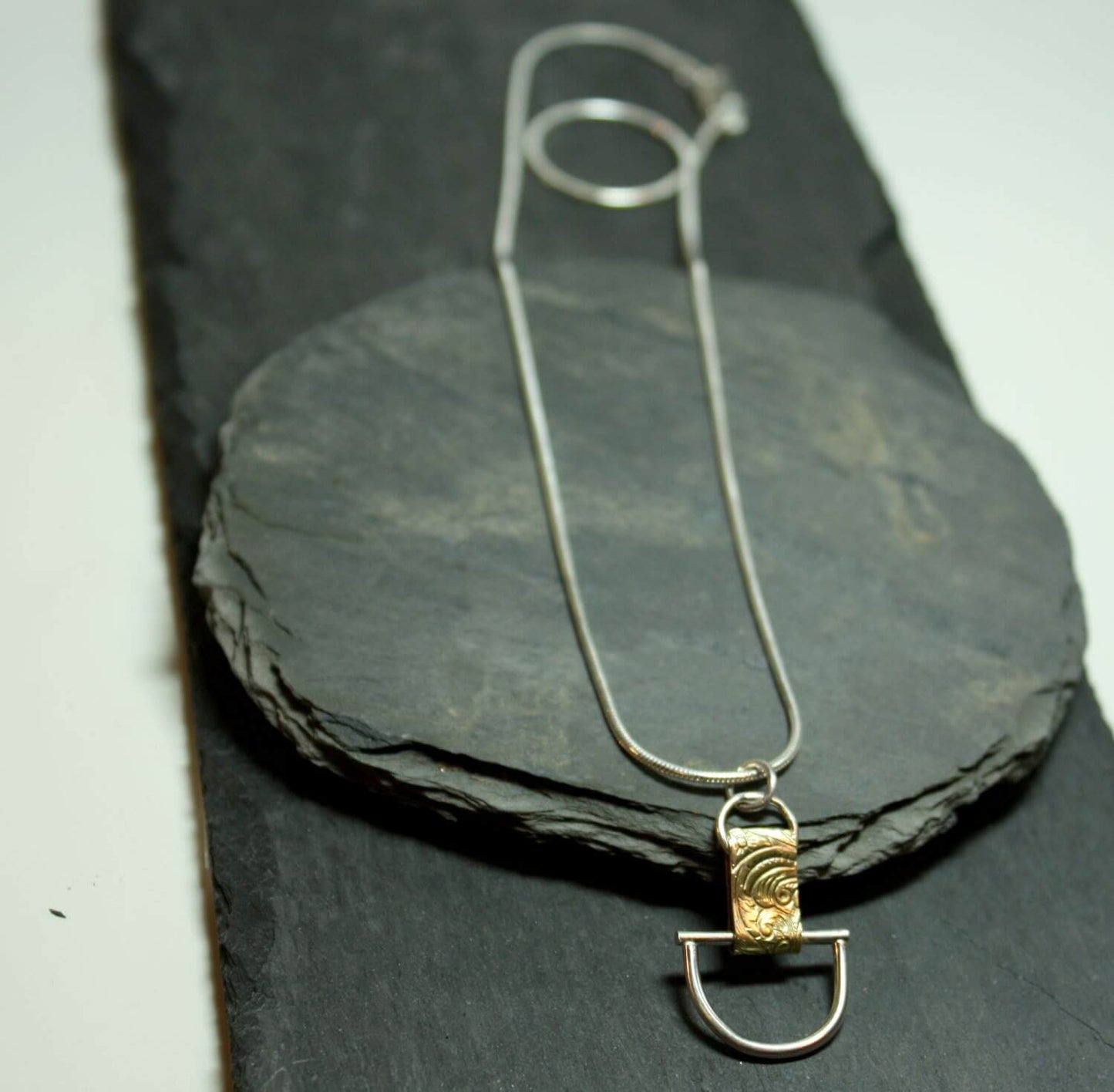 Arkitekturinspirerat handgjort silverhalsband av silver och mässing