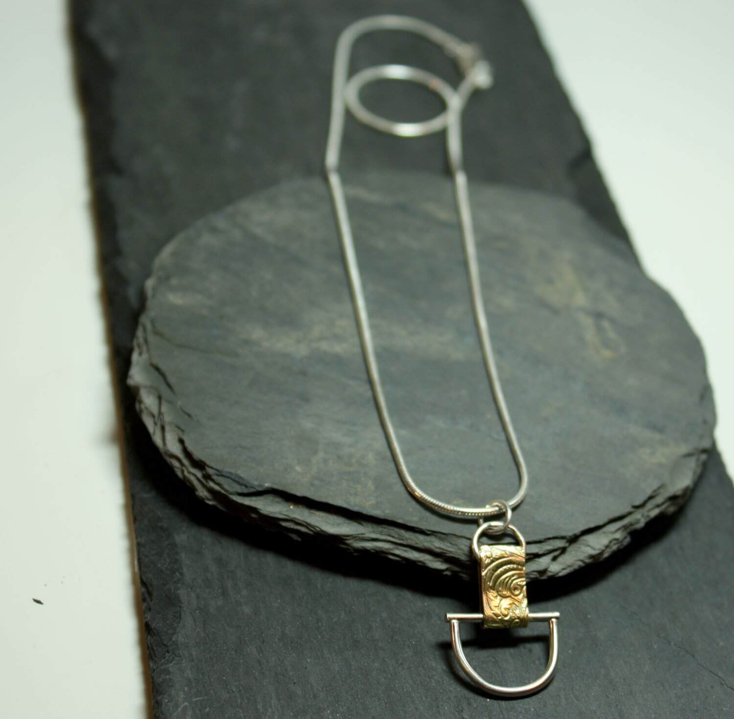 Arkitekturinspirerat handgjort silverhalsband av silver och mässing