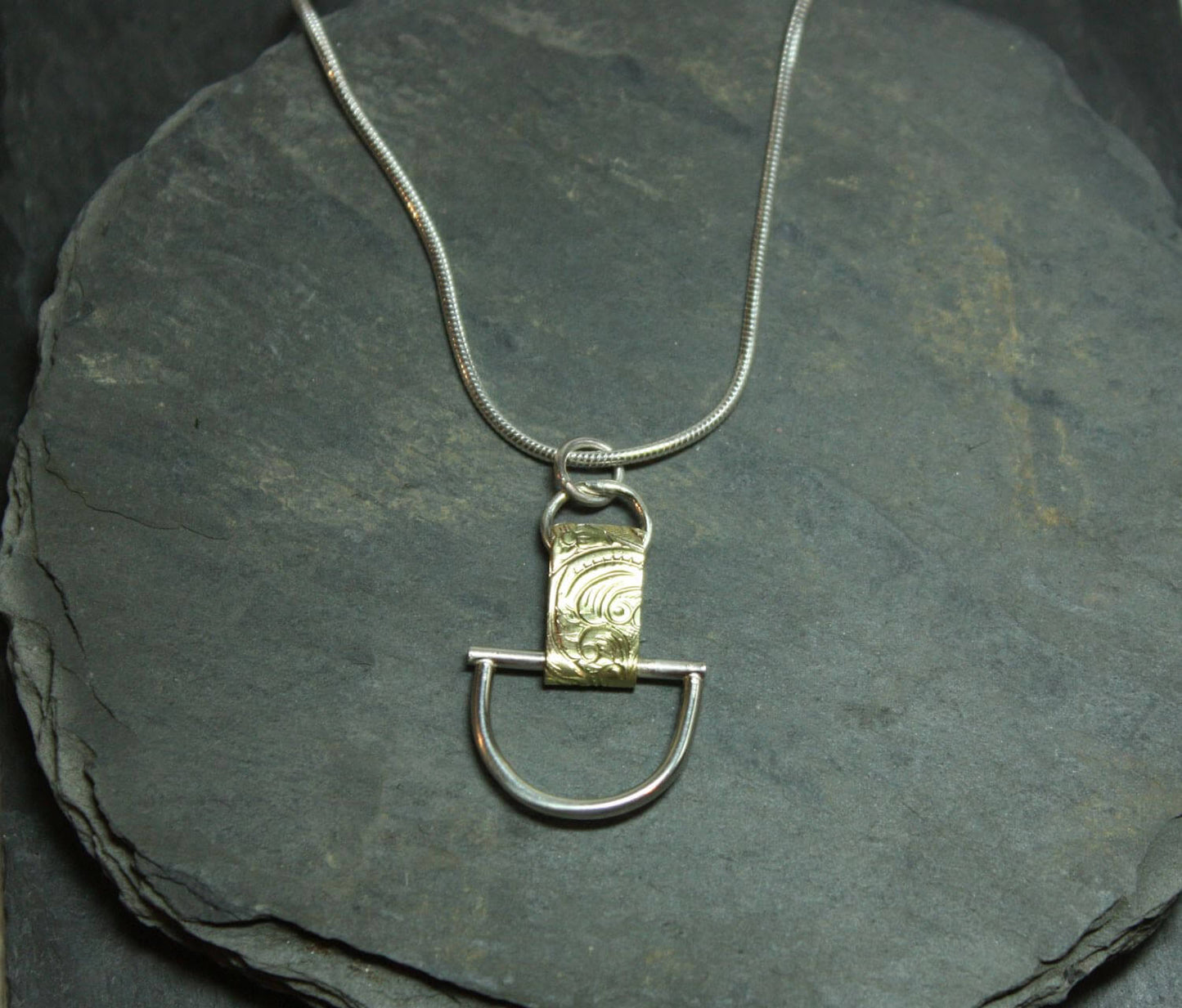 Arkitekturinspirerat handgjort silverhalsband av silver och mässing