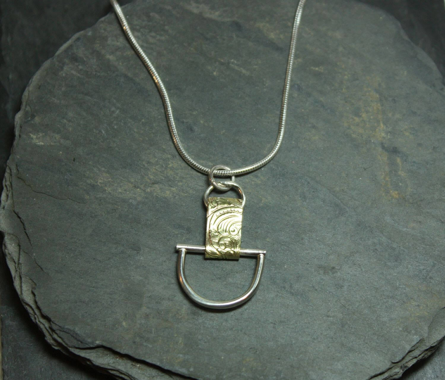 Arkitekturinspirerat handgjort silverhalsband av silver och mässing